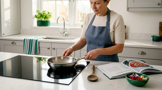 Cook placing pan on induction hob in kitchen